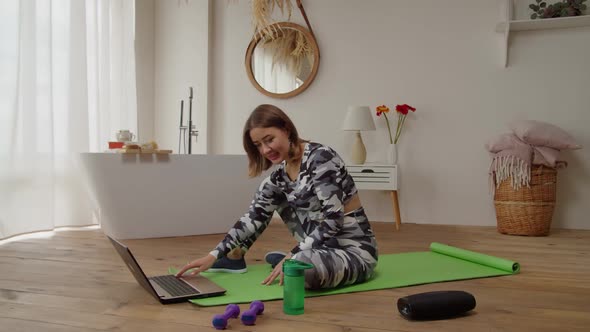 Sporty Fit Lovely Woman Searching Online Fitness Class on Laptop Pc in Loft Apartment alt
