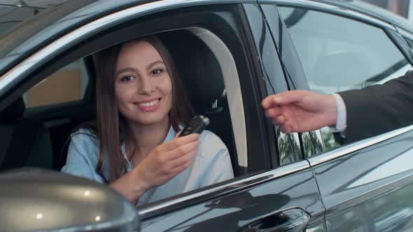 Sales Manager Handing Over the Keys To Girl That Sitting in the Car.