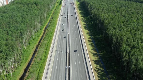 Asphalt Speedway with Cars Through Green Field. Aerial View From Drone alt