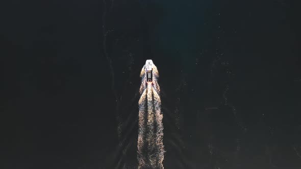 Aerial top down view of a boat at sea in Scotland with beautiful water at sun
