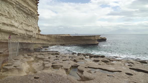 Holes Formed in Stone Ground Filled With Water in St Peters Pool Stone Beach in Malta