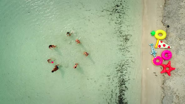 Aerial view of family playing volleyball in sea by sandy beach. alt
