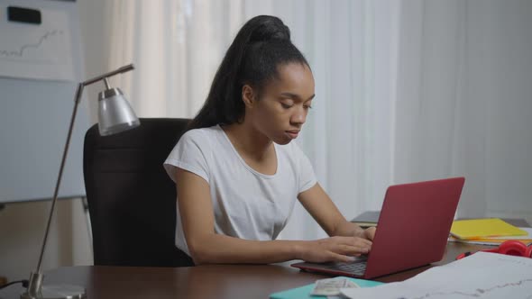 Young Exhausted Tired African American Woman Typing on Keyboard Closing Laptop Putting Head on Table alt