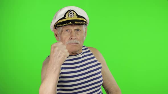 Elderly Sailor Man Is Angry and Shows a Fist. Sailorman on Chroma Key Background alt