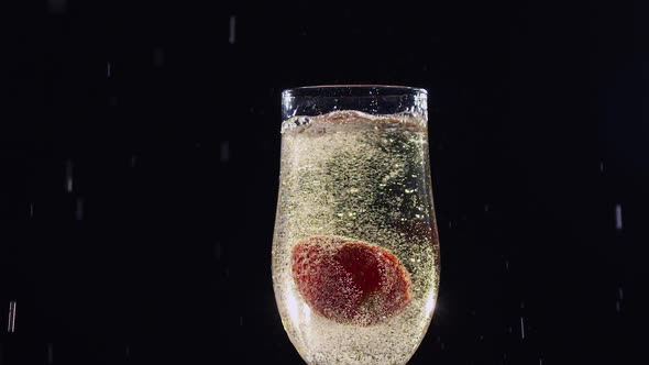 Mellow Strawberry Falling in Glass with Champagne Wine. Slow Motion alt