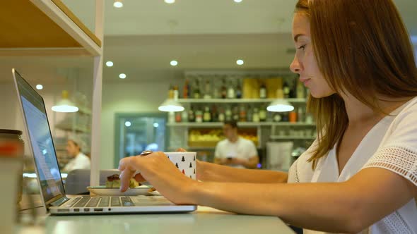 Cute Woman Using a Notebook in a Cafe