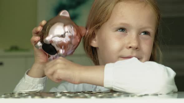 Girl Preschooler Puts Money in a Piggy Bank Pink Pig