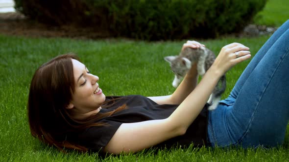 Woman Stroking Kitten in Garden