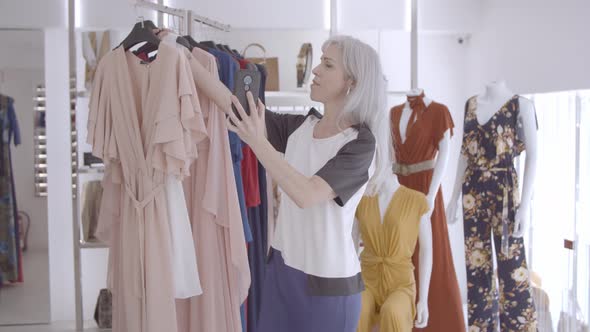 Woman Talking on Smartphone in Fashion Store alt