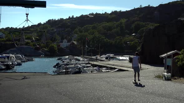 Young guy is longboarding at the docks on the beach in Norway at Kjerringvik alt