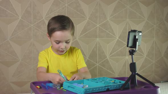 Boy Leads a Video Blog for Children with a Smartphone on a Tripod. Production of Children's Content alt