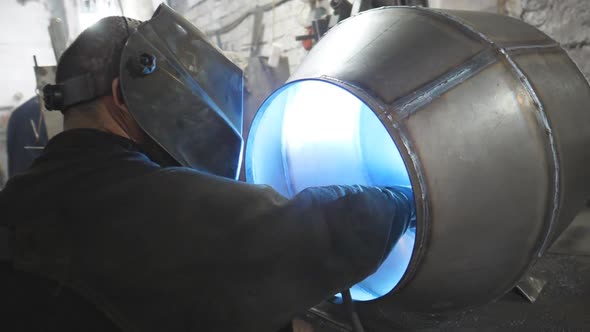 Worker in Protective Mask Welding Metal Construction at Industrial Production alt