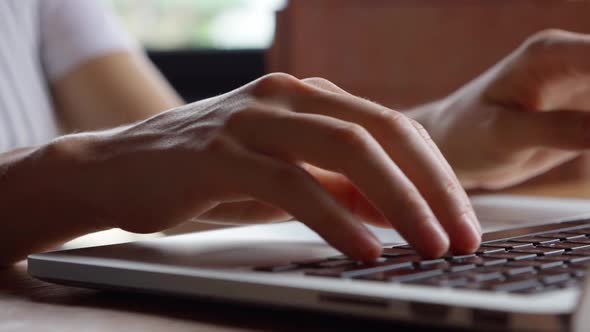 Close up of woman's hands typing on laptop.  alt