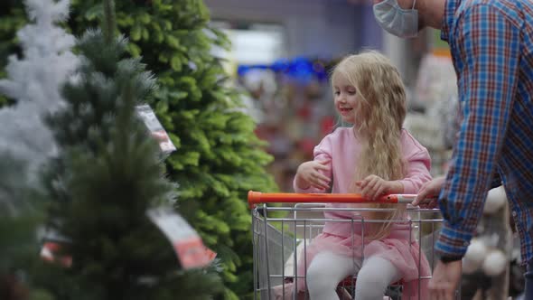 Dad and Child Choose Christmas Toys on the Store Shelf alt