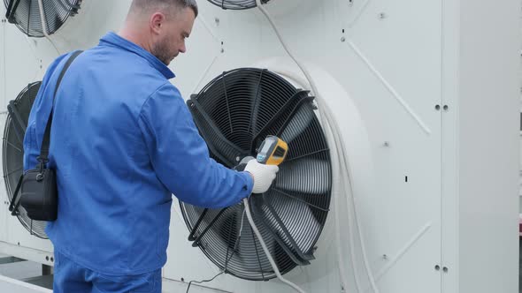 Technician uses a thermal imaging infrared thermometer to check the condensing alt