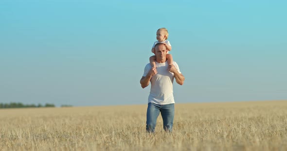 Father Walks in a Wheat Field with His Baby Daughter