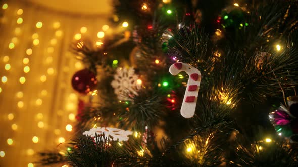 Closeup of Traditional Decorations Baubles and Light Garlands Hanging on Christmas Tree at Night alt