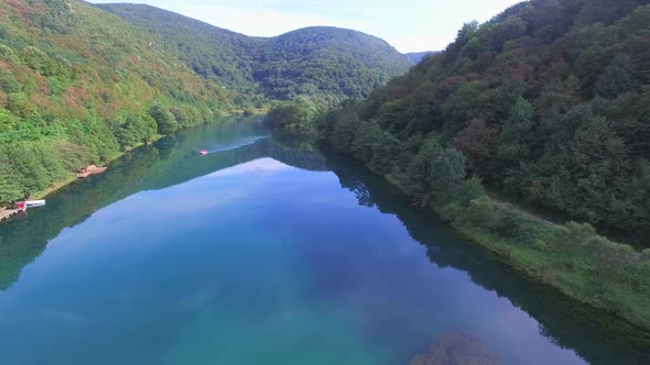 Aerial view of rafters paddling through still water of Una river in Bosnia alt
