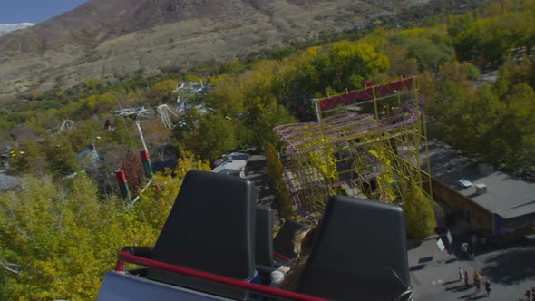 Slow motion shot from the back of a rollercoaster riding the twists of the track. alt