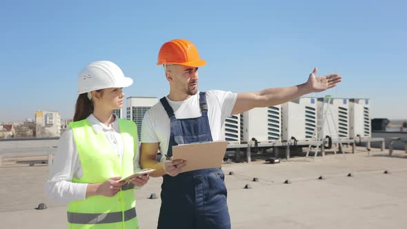 Two Engineers are Discussing the Work Done to Install the Air Conditioning System alt