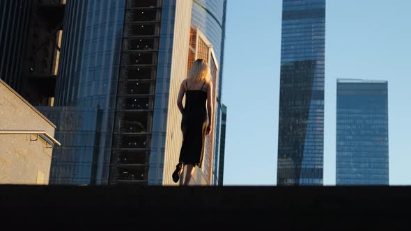 beautiful woman climbs the stairs to the skyscrapers