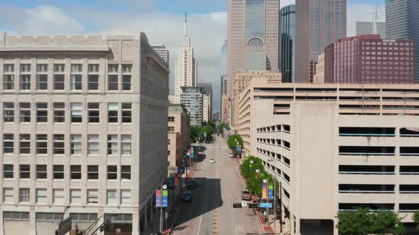 View From Forwards Flying Drone Above Street Downtown Heading to Group of Skyscrapers alt