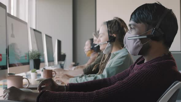Call Center Operators in Face Masks Taking Calls alt