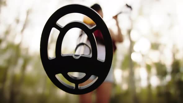 Young Woman Archeologist Using Metal Detector in the Forest. Low Angle View alt