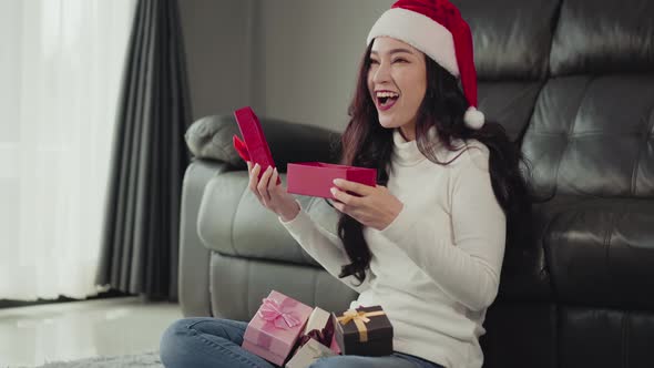 surprise woman opening christmas gift in the living room