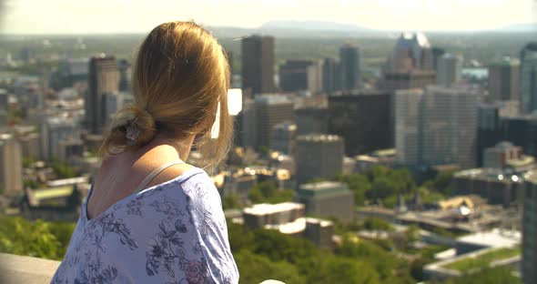 Happy Woman in Mask Standing Looking at City alt
