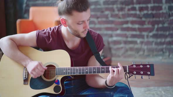 Handsome Young Man Playing Acoustic Guitar Sitting Floor Living Loft Room alt