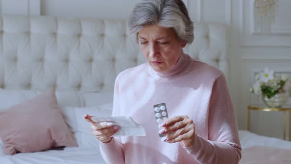 An Elderly Woman with Tablets in Her Hands and Reads a Prescription Medication alt