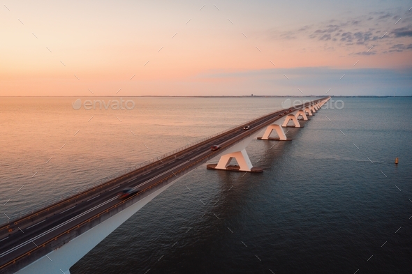 Long bridge going over the magnificent ocean under the beautiful colorful sky - Stock Photo - Images
