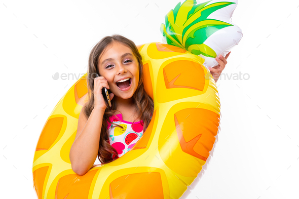 girl with an inflatable swimming ring speaks on the phone on a white background