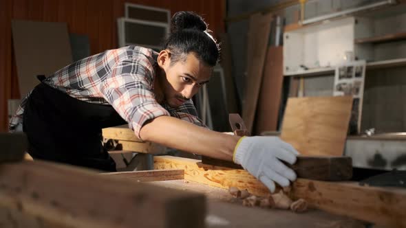 Young Asian man carpenters are using spokeshave to decorate the woodwork. alt