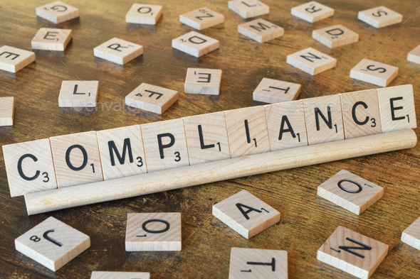 Wooden letter tiles spelling out the word Compliance - Stock Photo - Images