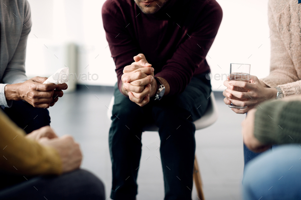Close-up of people siting in a circle during group therapy meeting. - Stock Photo - Images