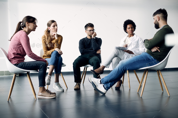 Group of people having a therapy meeting with African American psychotherapist at medical center. - Stock Photo - Images