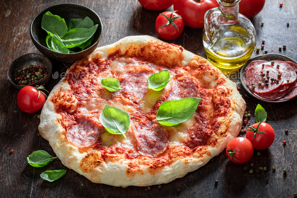 Spicy pepperoni pizza on wooden table. Classic Italian cuisine. - Stock Photo - Images