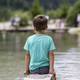 Young boy sitting by lake - PhotoDune Item for Sale
