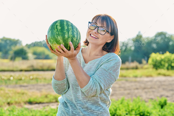 Smiling woman with ripe watermelon outdoor - Stock Photo - Images