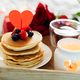 Valentine&#39;s day breakfast or brunch. Homemade pancakes with berries, cup of tea and red roses. - PhotoDune Item for Sale