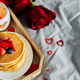 Pancakes in the shape of a heart with berries, roses flowers, cup of tea and candle in candlestick. - PhotoDune Item for Sale