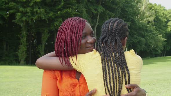 Affectionate Black Mother Hugging Teenage Daughter Outdoors alt