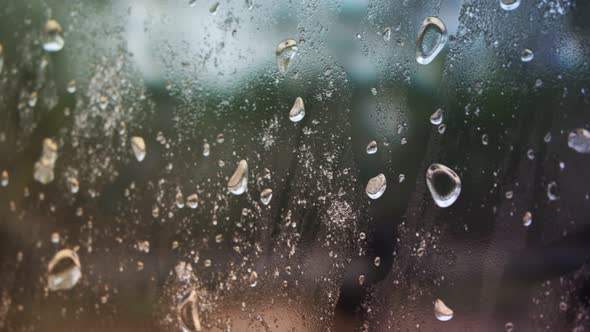 Camera moving slowly next to a window full of water droplets and condensation.
