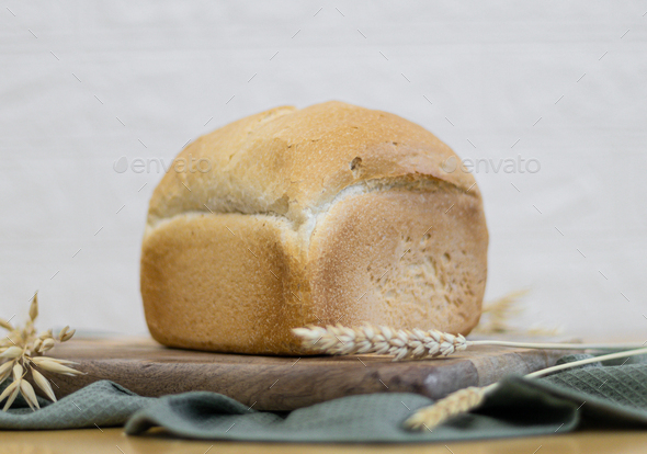 One white round bread with wheat fiber on the table.