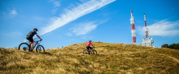 Mountain bikers going up the Nanos plateau in Slovenia under a blue sky - Stock Photo - Images