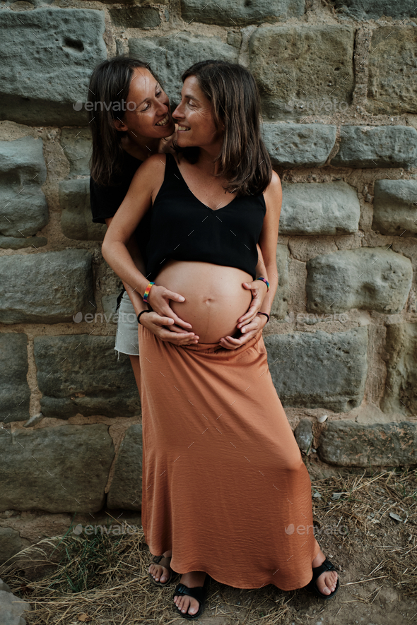 Vertical Closeup Of A Pregnant Lesbian Couple Doing A Photoshoot In A