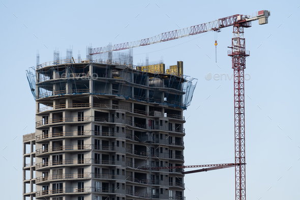 Multi-storey residential building with tower crane during construction stop and mortgage crisis - Stock Photo - Images
