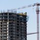 Multi-storey residential building with tower crane during construction stop and mortgage crisis - PhotoDune Item for Sale